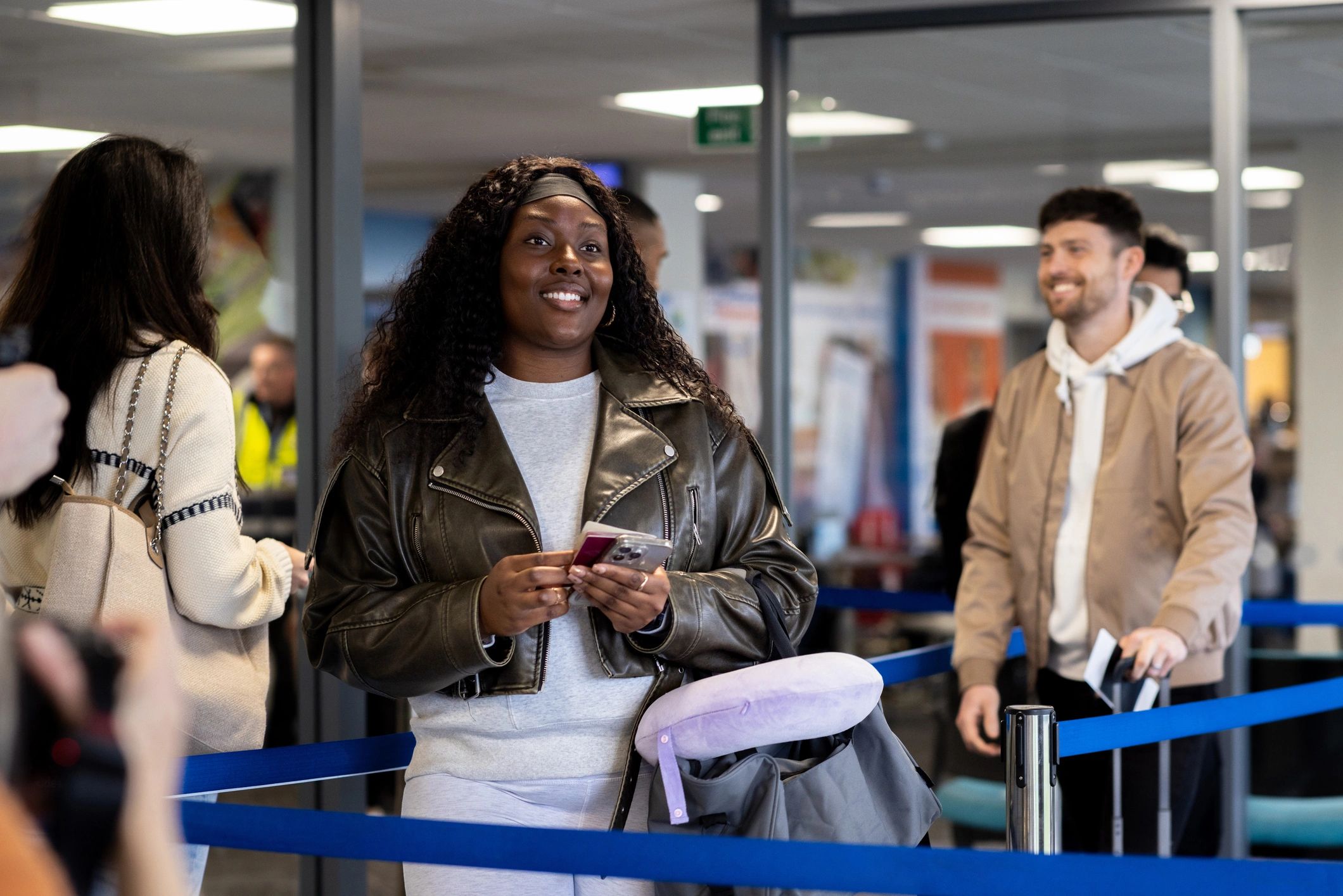 Travelers waiting with boarding passes at airport gate