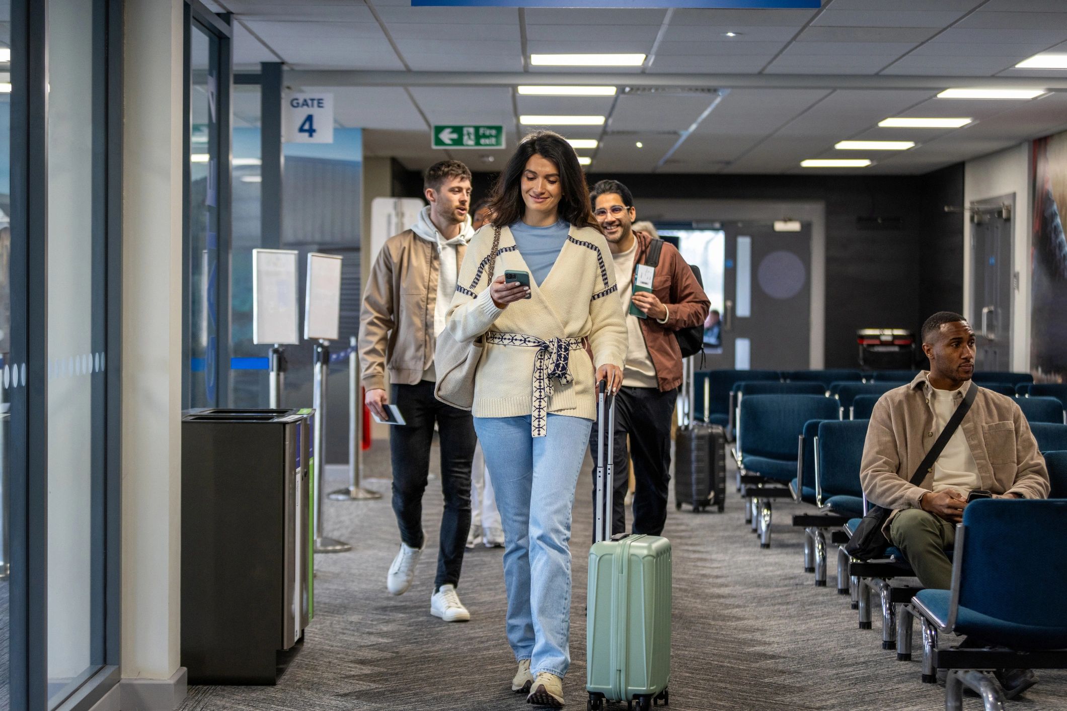 Travelers moving through an airport with boarding passes